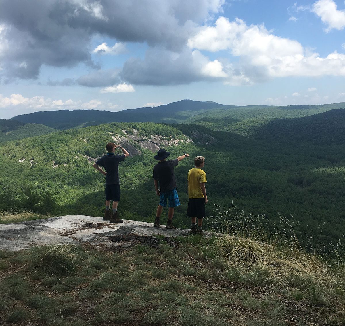 teenage boys hiking on rock in north carolina mountains