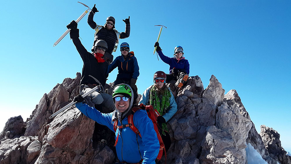 teenagers standing on mount shasta mountain summit