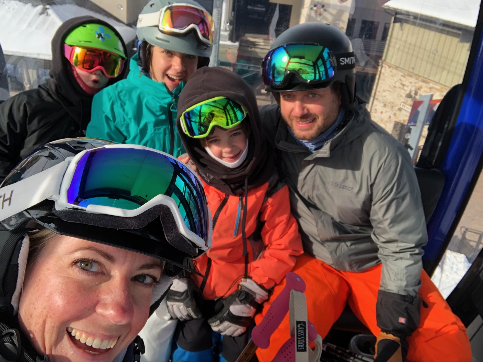 family huddling together with ski goggles and masks