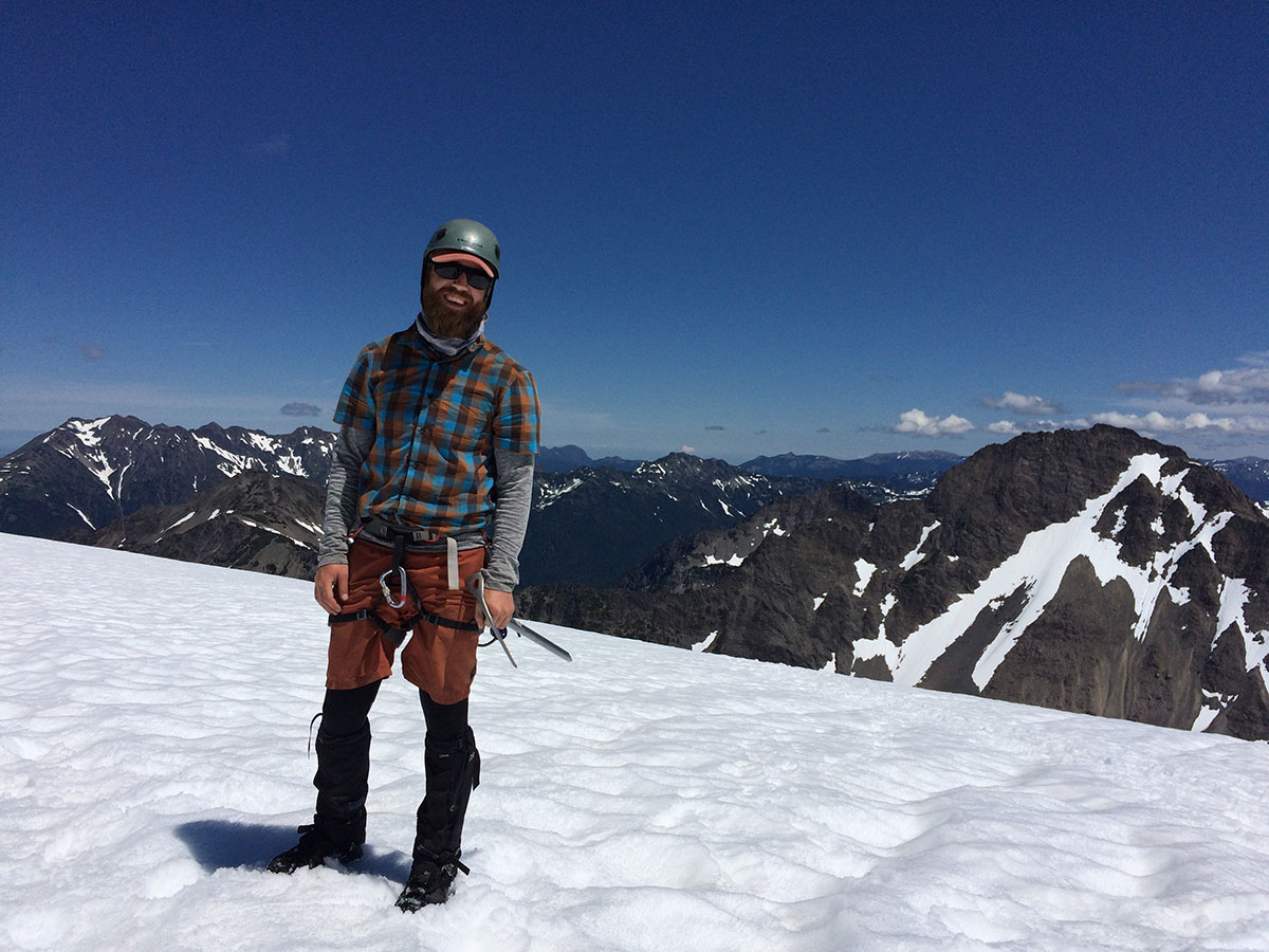 man in beard standing on snowy mountain