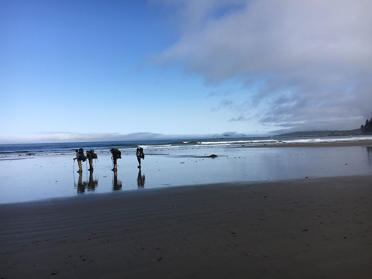 teenagers hiking on beach on olympic peninsula washington