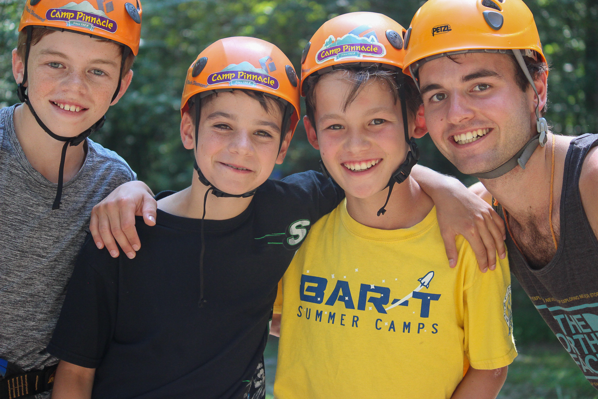 male campers and male counselors at summer camp wearing helmets