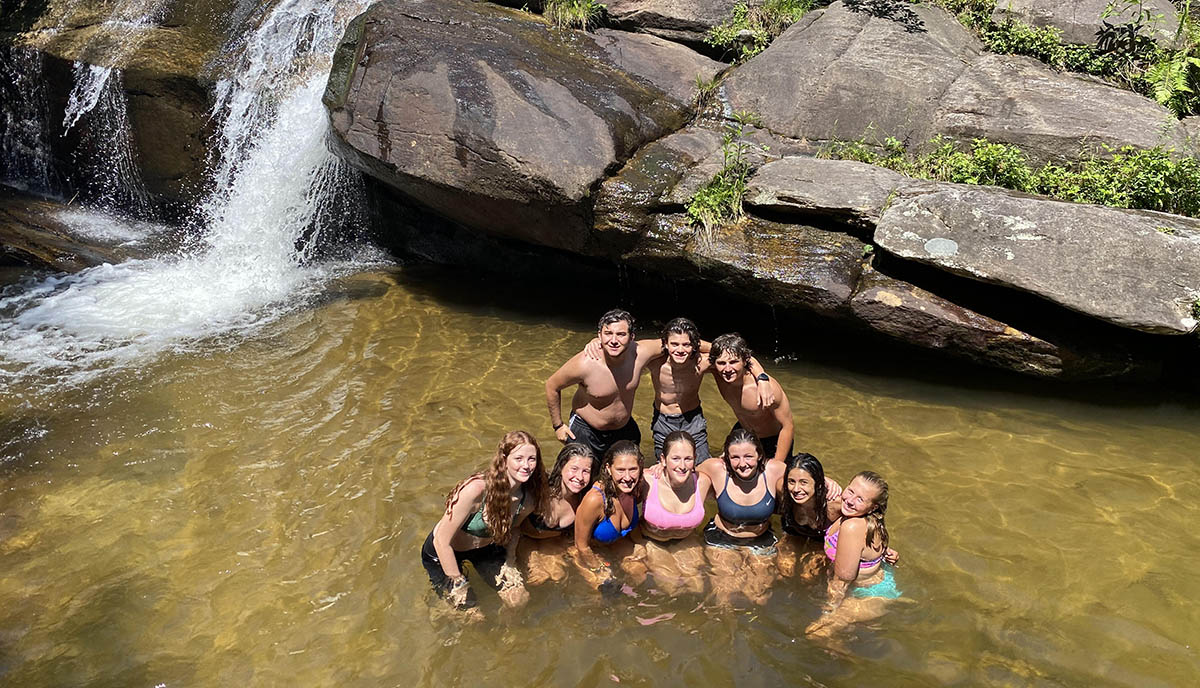 teenage boys and girls standing in a group in a river